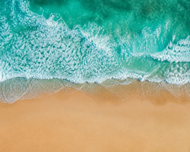 Aerial turquoise waves meeting the beach, generated with Image Studio